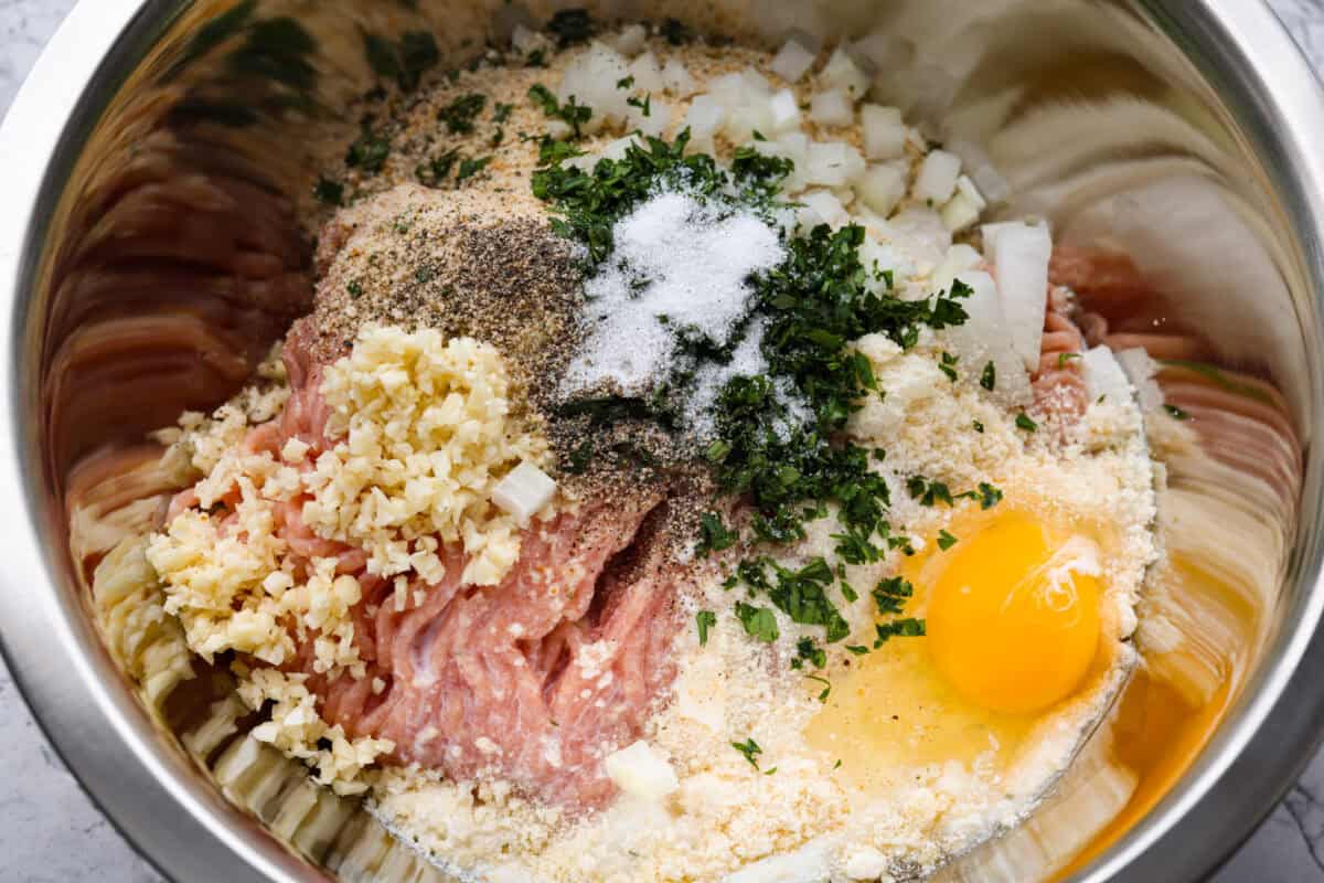 All of the meatloaf ingredients in a bowl before they have been mixed together.