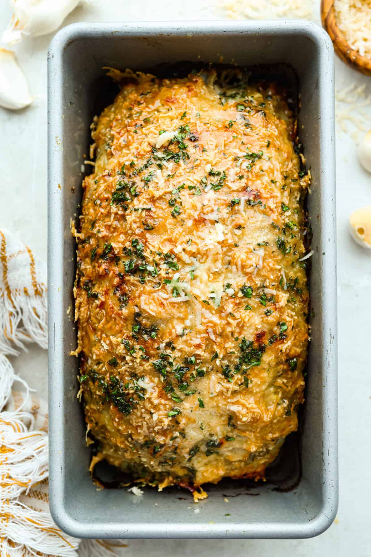 Overhead shot of garlic parmesan chicken meatloaf in the loaf pan. 
