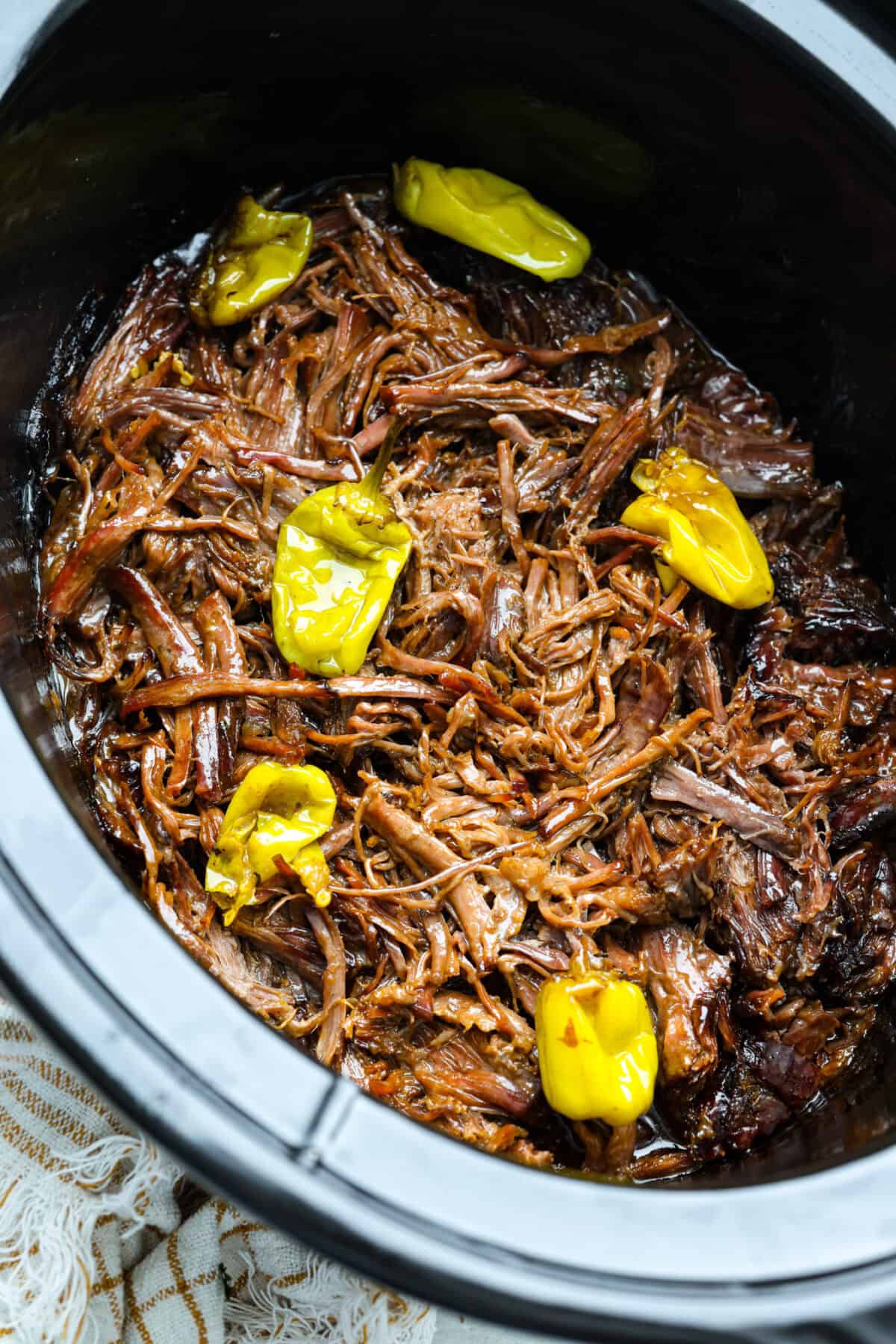 Overhead shot of Mississippi pot roast shredded in the crockpot.