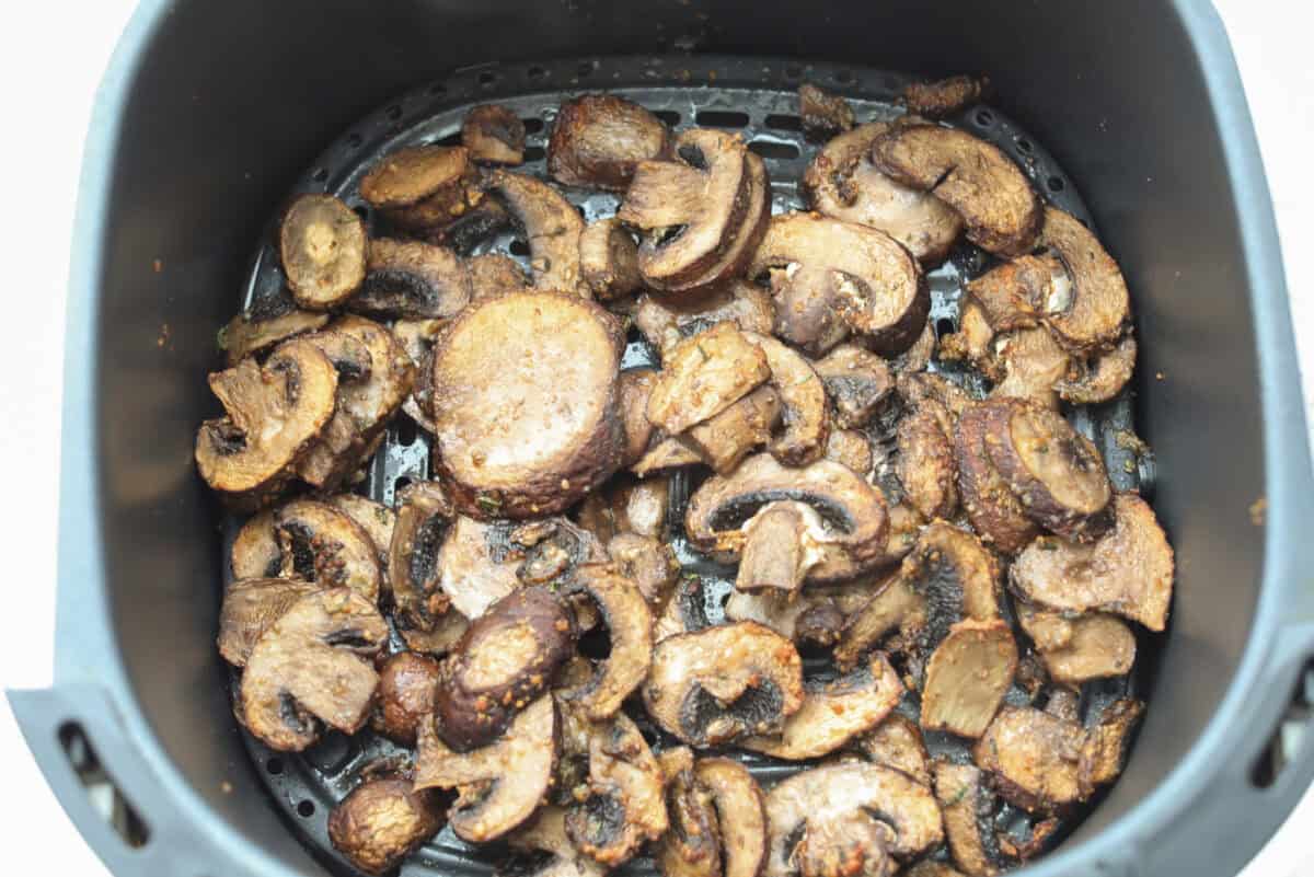Mushrooms in the bottom of the air fryer basket. 