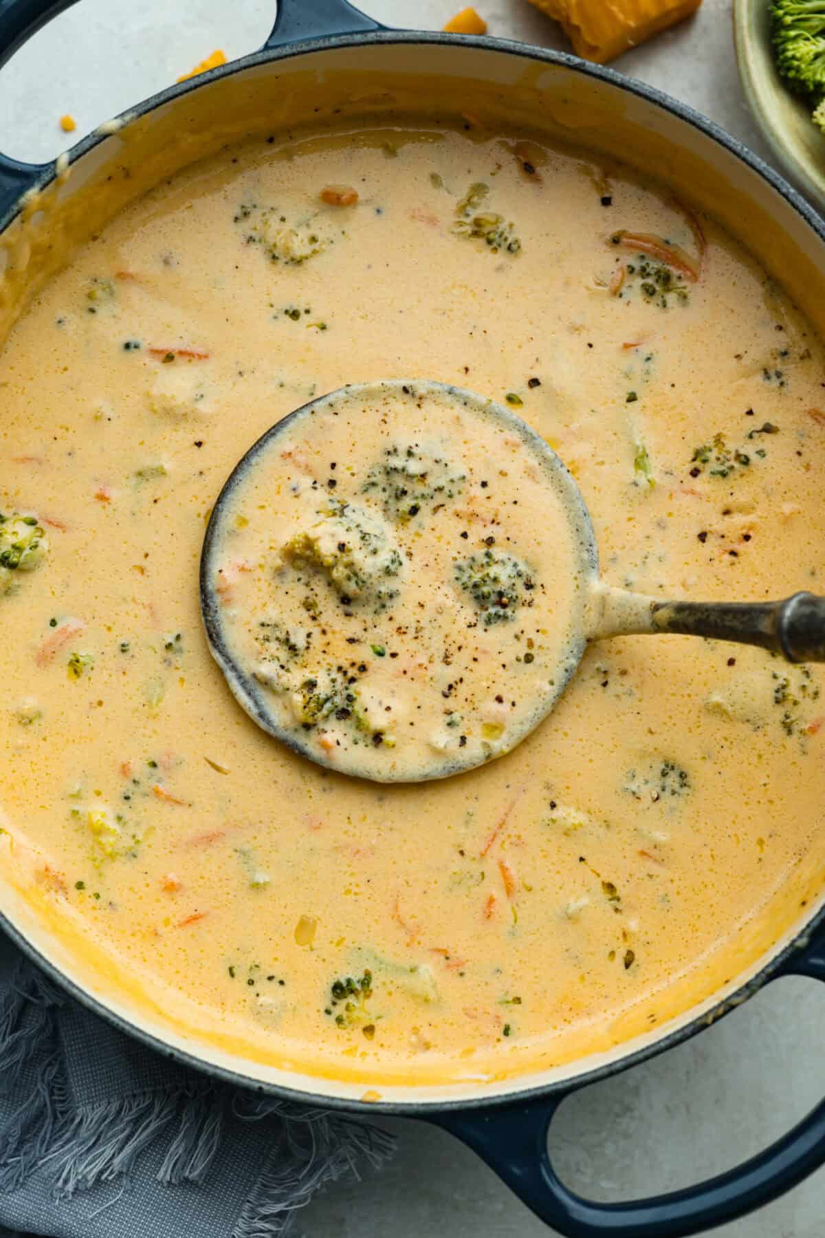 Overhead shot of Panera broccoli  cheddar soup in a pot with a ladel.