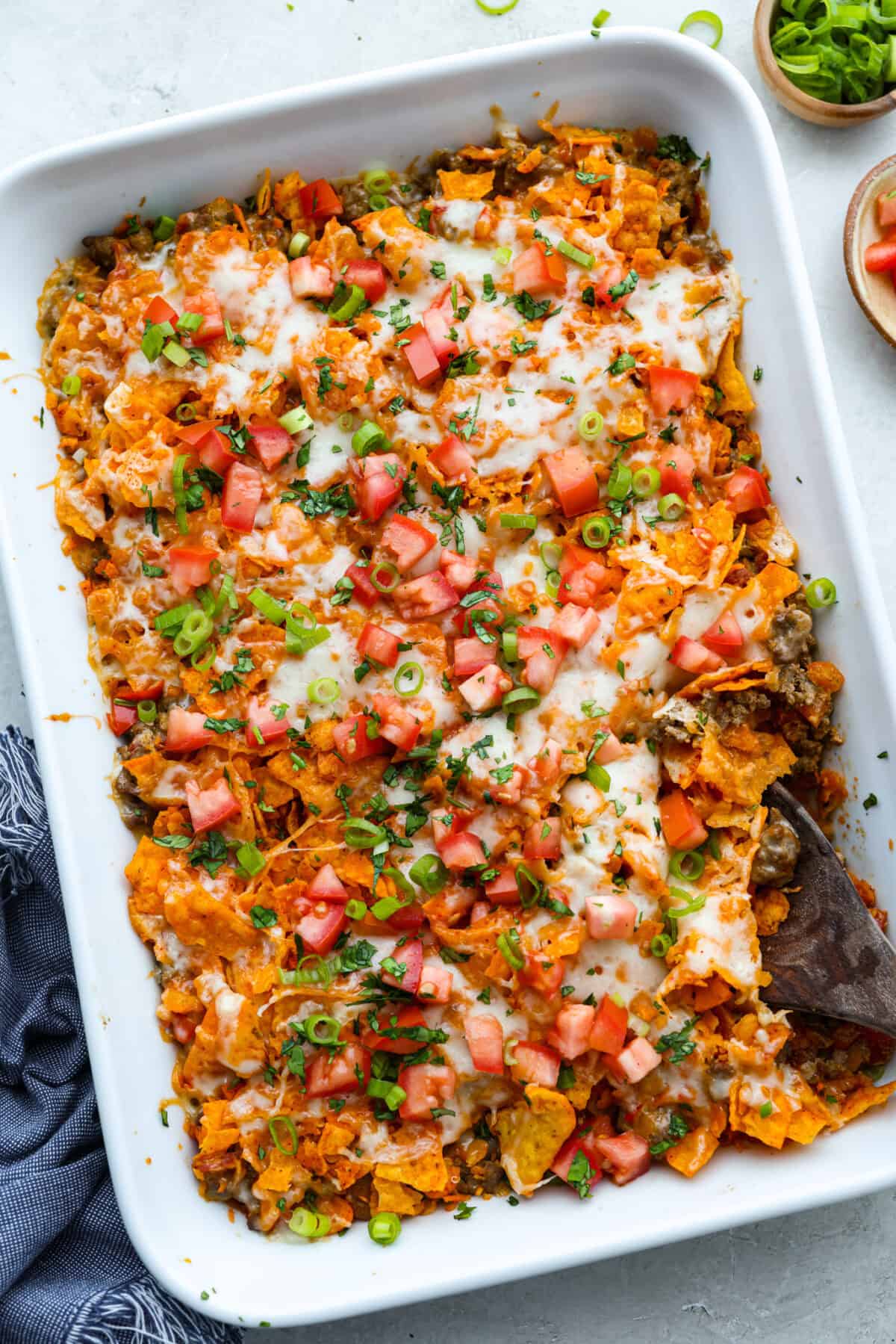 Doritos casserole baked and topped with green onion, tomatoes and chopped cilantro. 