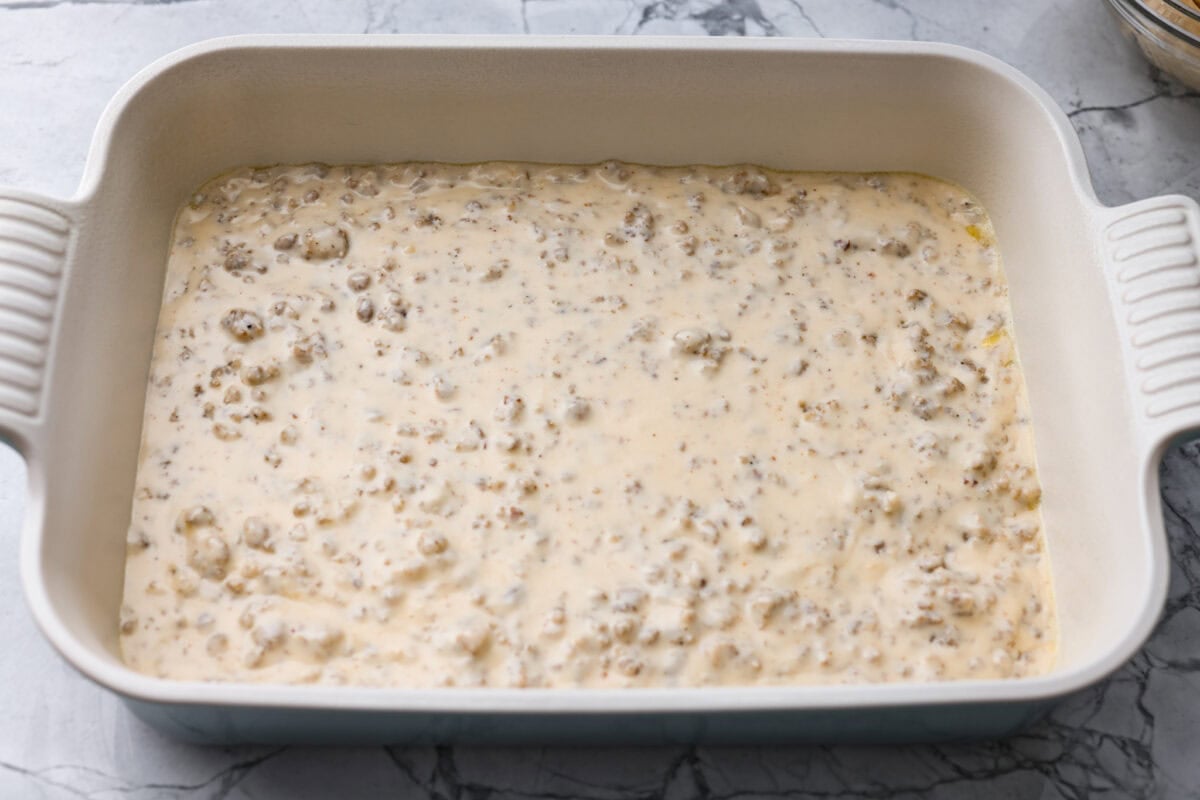 Sausage gravy added to the bottom of the baking dish.