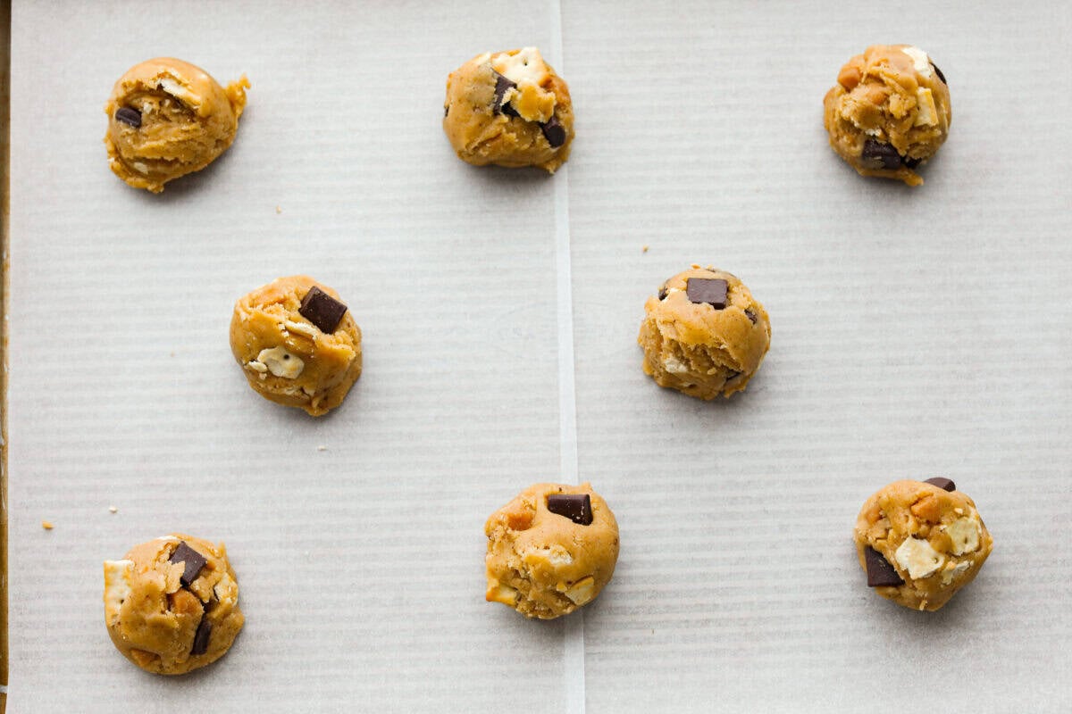Christmas crack cookie dough balls spread evenly on a cookie sheet.