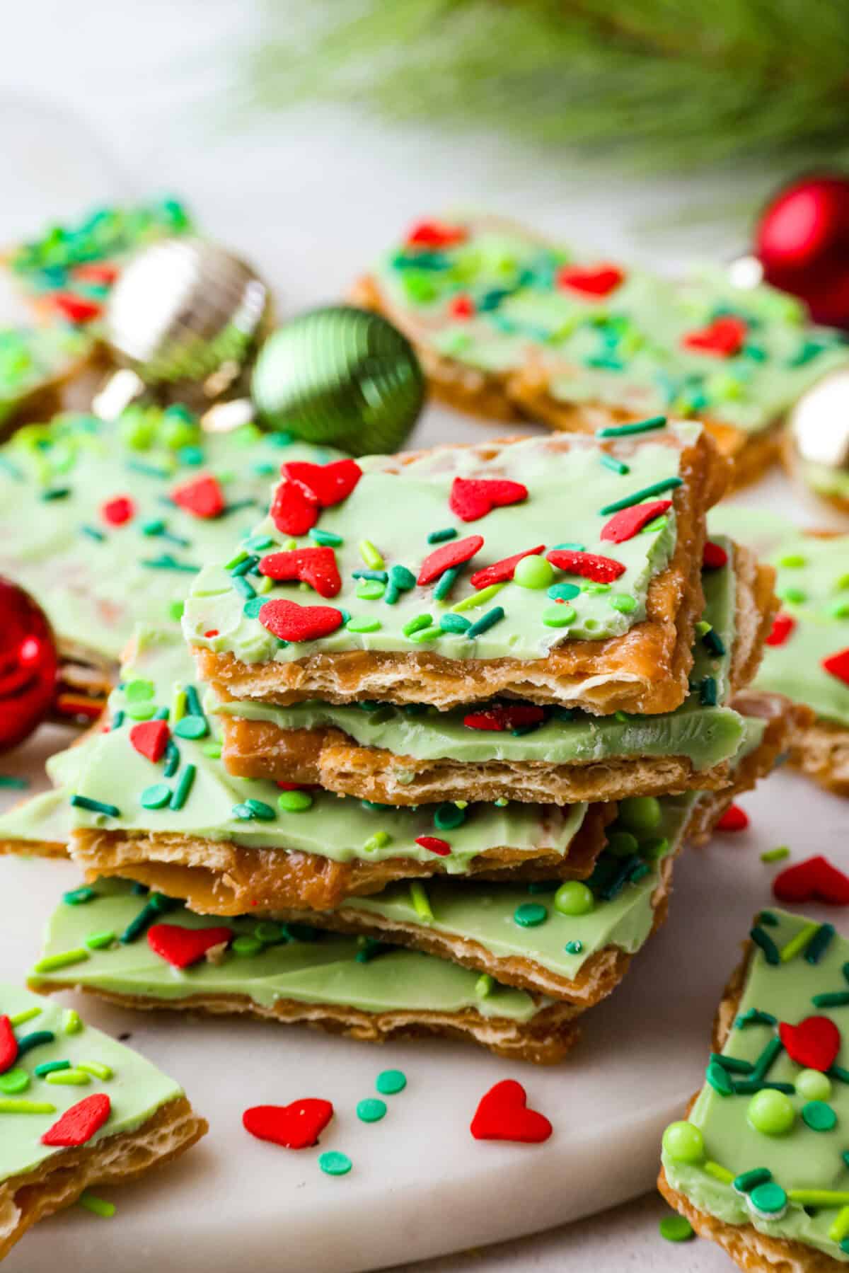 Stack Grinch Christmas crack in fornt of some Christmas bobbles.