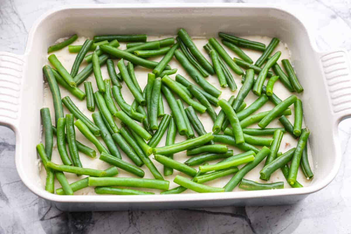 Green beans sprinkled on top of the mashed potatoes. 