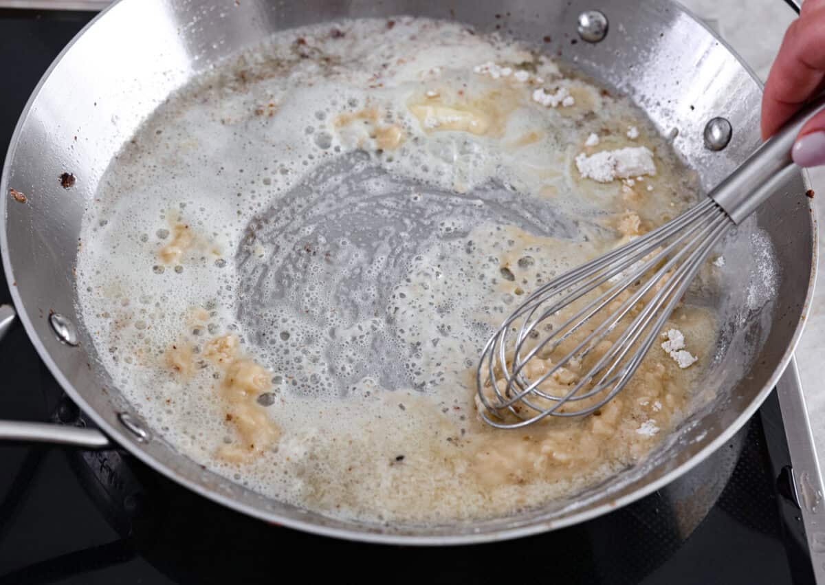 Cooking a roux with butter and flour in a saucepan with a whisk. 