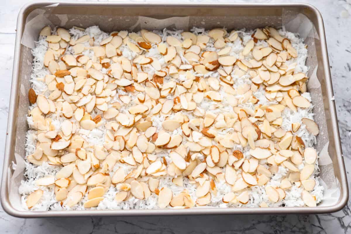 Sliced almonds layered over the top of the coconut. 