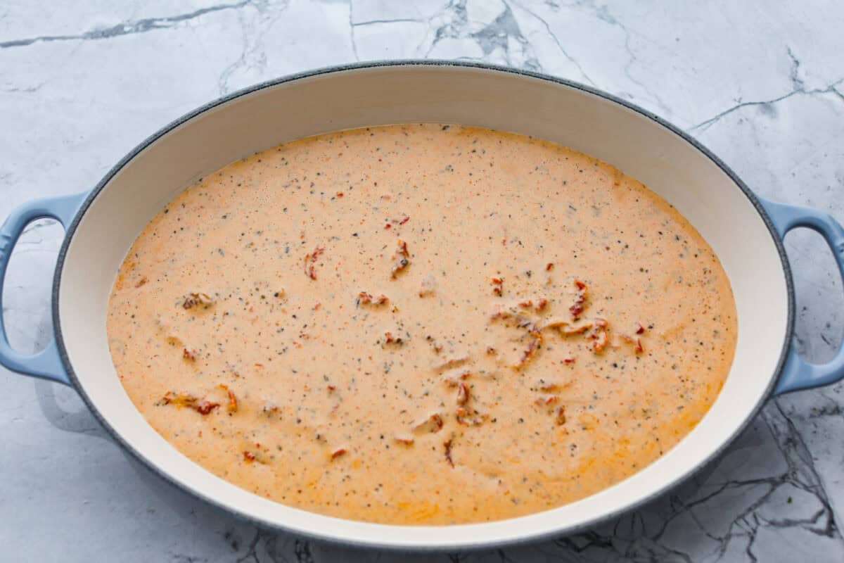 Some of the sauce added to the bottom of the baking dish.