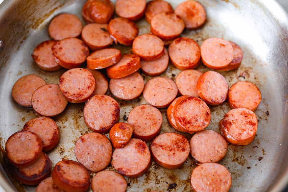 Sausage browning in a pan. 