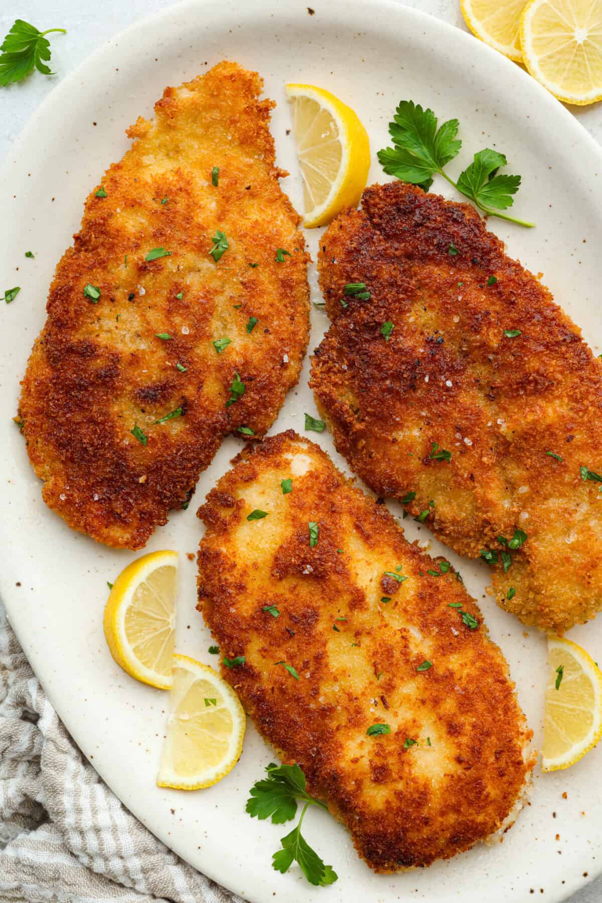Platter with chicken schnitzel on it.