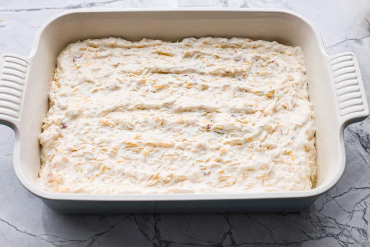Chicken mixture spread out in a baking dish. 