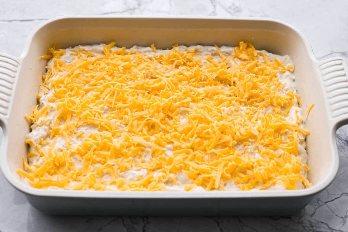 Chicken mixture covered in cheese ready to be baked. 