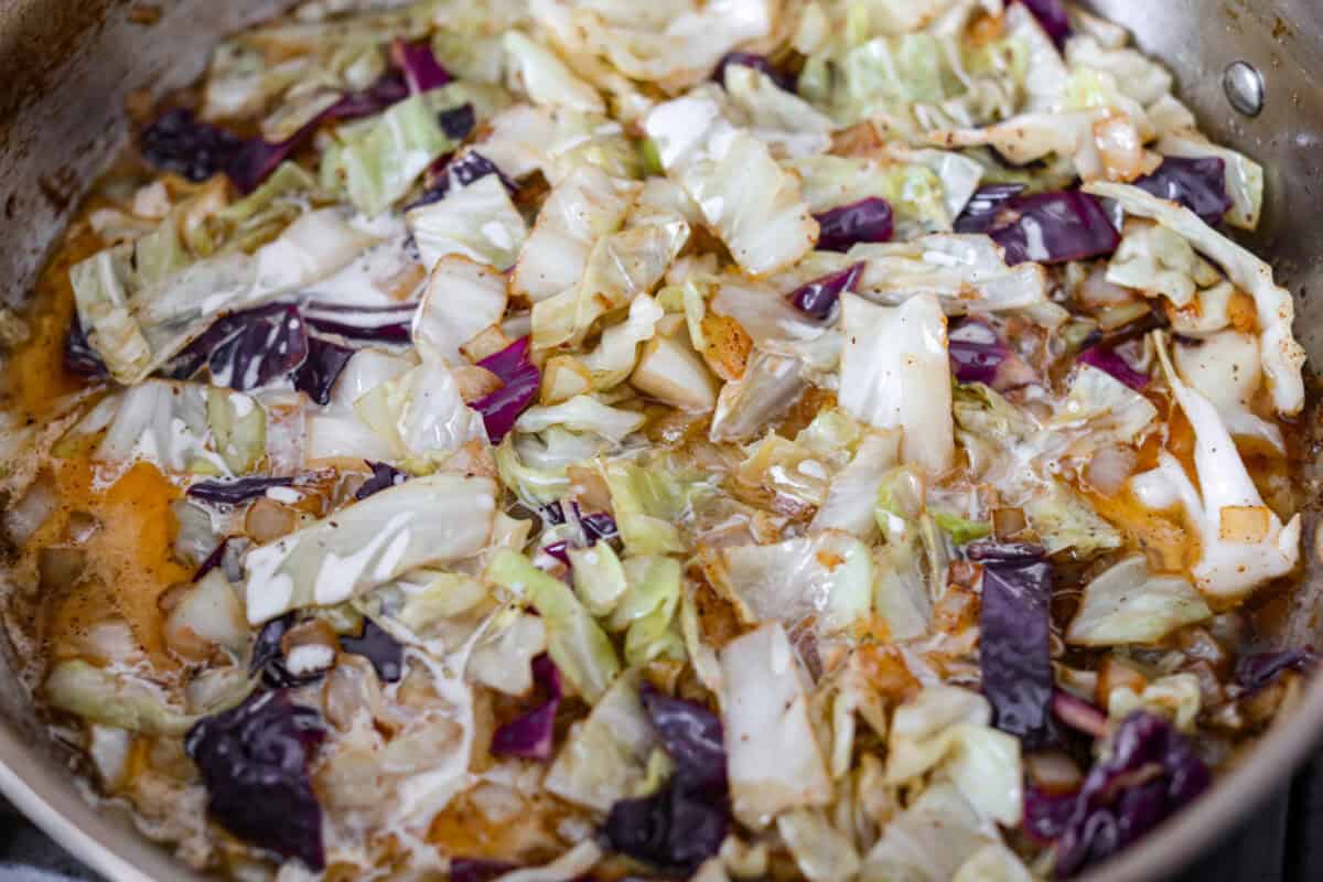 This Irish chicken is my cozy mashup of pub vibes and weeknight reality. Seared chicken thighs baked over bacon, cabbage, and potatoes, then I add a splash of Irish whiskey and a touch of cream to make the whole pan taste extra special. Cabbage, chicken broth, cream, and whiskey added to the skillet.