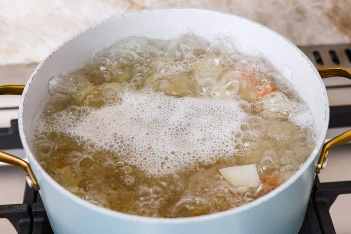 You guys have been asking, so I made the change. This Crack Potato Salad now has mayonnaise in the dressing! It seriously takes the flavors up a notch! I love the combination with the sour cream. I can't wait for you to try this new version! Pot of boiling water with diced potatoes cooking in it.