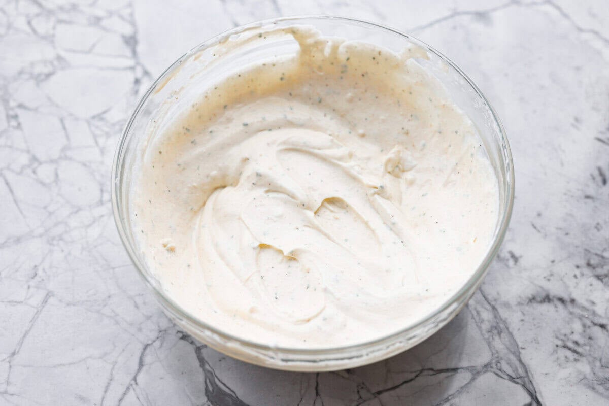 You guys have been asking, so I made the change. This Crack Potato Salad now has mayonnaise in the dressing! It seriously takes the flavors up a notch! I love the combination with the sour cream. I can't wait for you to try this new version! Sour cream and mayonnaise mixed together with the ranch seasoning in a mixing bowl.