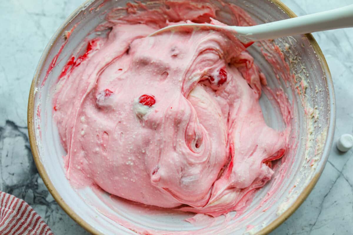 Fluff salads never go out of style. They're light, creamy, and just plain fun! This cherry cheesecake fluff is customizable and so easy to throw together! It's packed with sweet-tangy cheesecake flavor and juicy cherries in every bite. Cherry pie filling added to the ream cheese mixture.