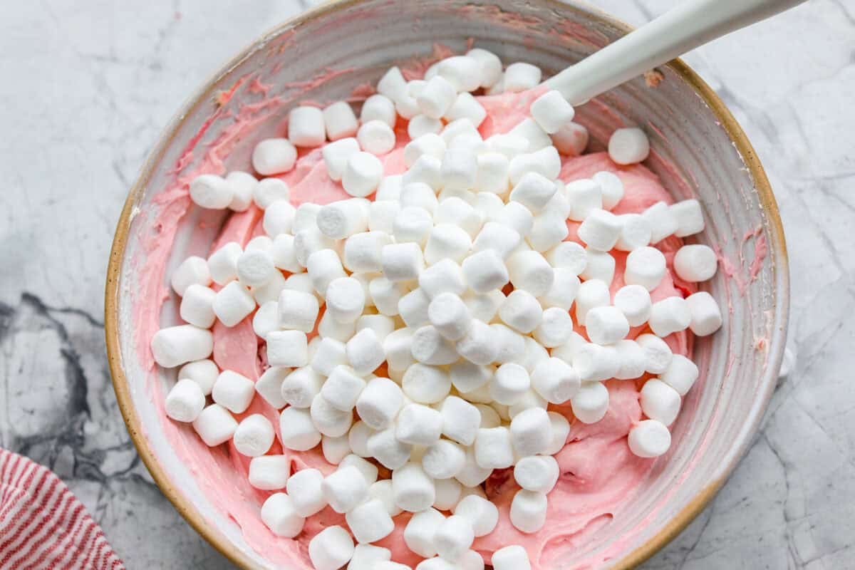 Fluff salads never go out of style. They're light, creamy, and just plain fun! This cherry cheesecake fluff is customizable and so easy to throw together! It's packed with sweet-tangy cheesecake flavor and juicy cherries in every bite. Marshmallows added to the mixture.