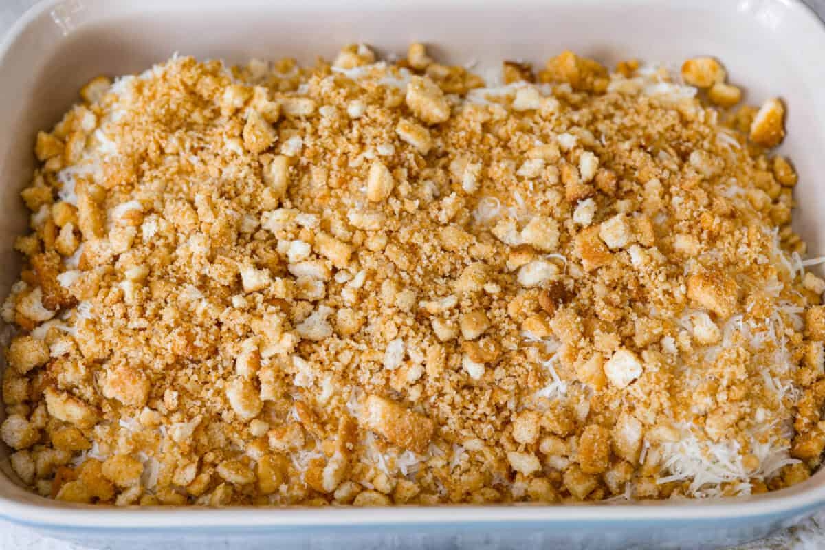 My Caesar chicken bake turns classic Caesar salad flavors into an easy one-pan dinner! Juicy chicken is smothered in creamy dressing, topped with parmesan and buttery crushed croutons, and baked to golden, cheesy perfection. Crushed croutons on top of the parmesan cheese.
