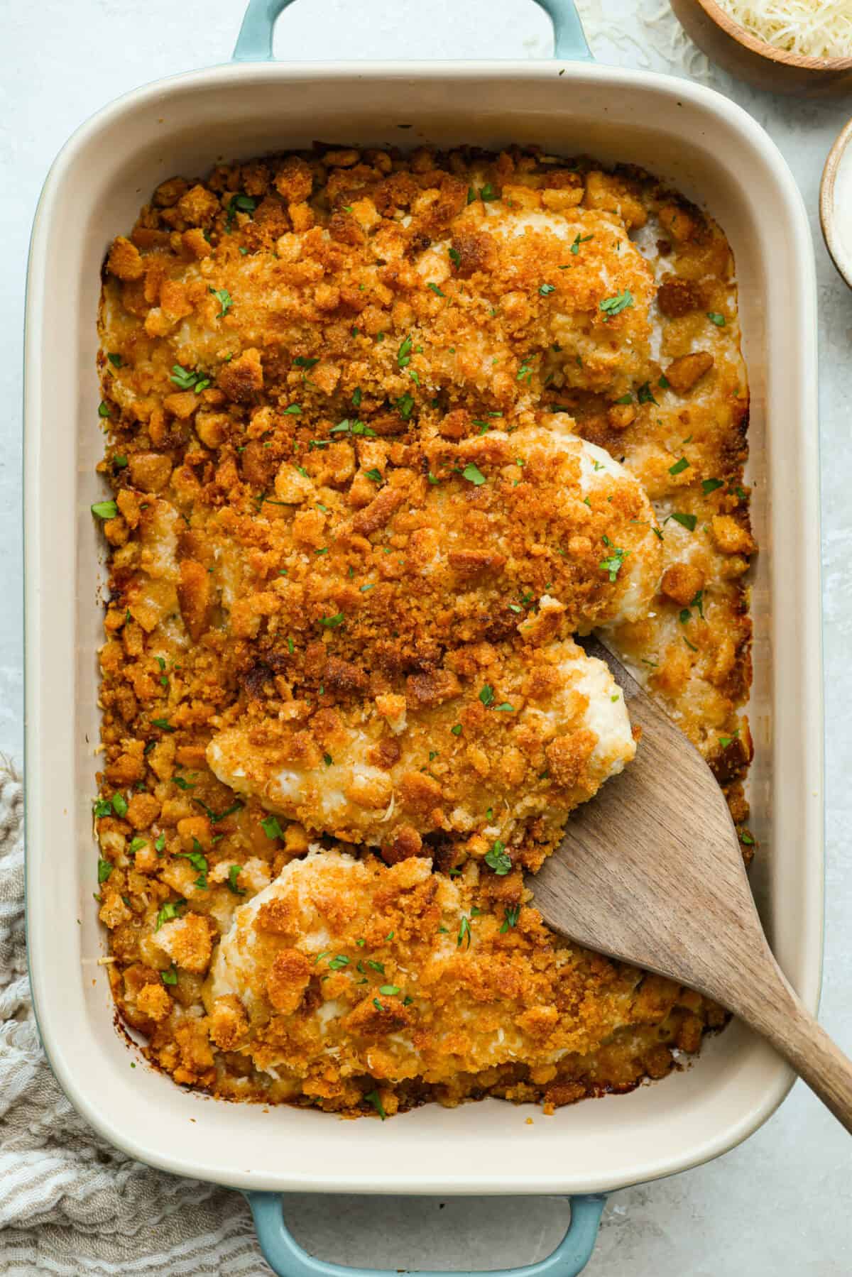 My Caesar chicken bake turns classic Caesar salad flavors into an easy one-pan dinner! Juicy chicken is smothered in creamy dressing, topped with parmesan and buttery crushed croutons, and baked to golden, cheesy perfection. Overhead shot of baked to perfection Caesar Chicken Bake in a baking dish.