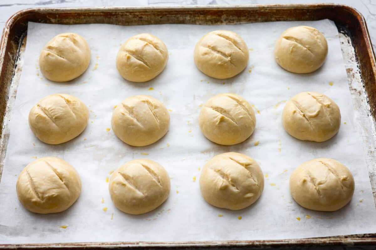 French bread dough balls scoured and covered in an  egg wash, ready to go in the oven. 