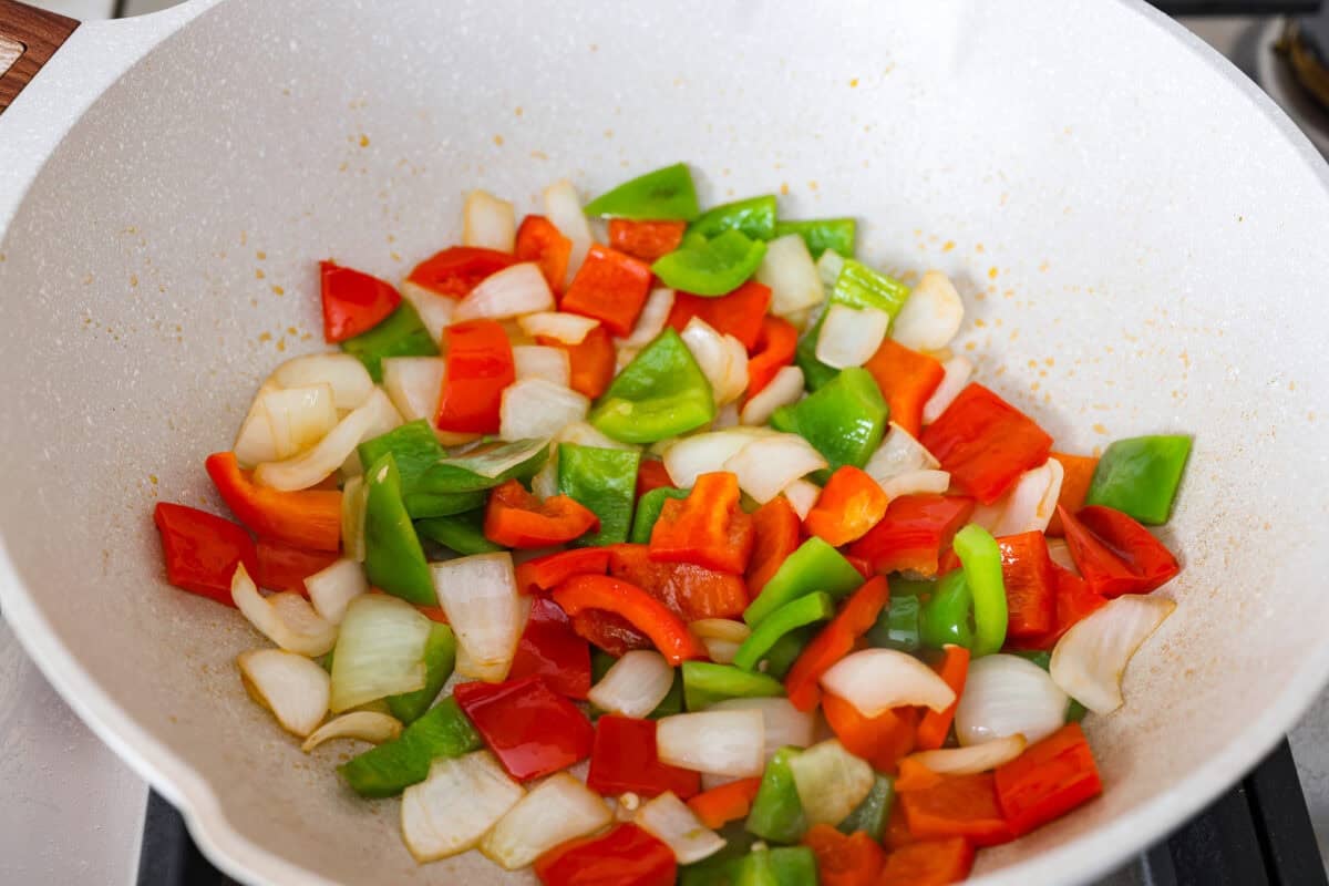 Veggies diced and bing cooked in a wok.