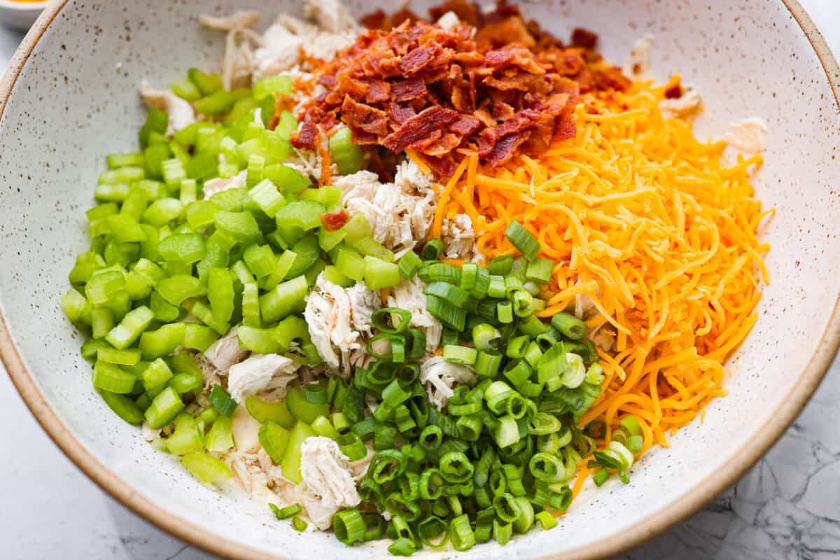 This crack chicken salad has no business being this good! It’s creamy, packed with ranch, bacon, and cheddar, and disappears way too fast. Pile it on a croissant or eat it straight from the bowl. I promise I won't judge! Cheese, bacon, chicken, celery, and green onions added to the sauce mixture.