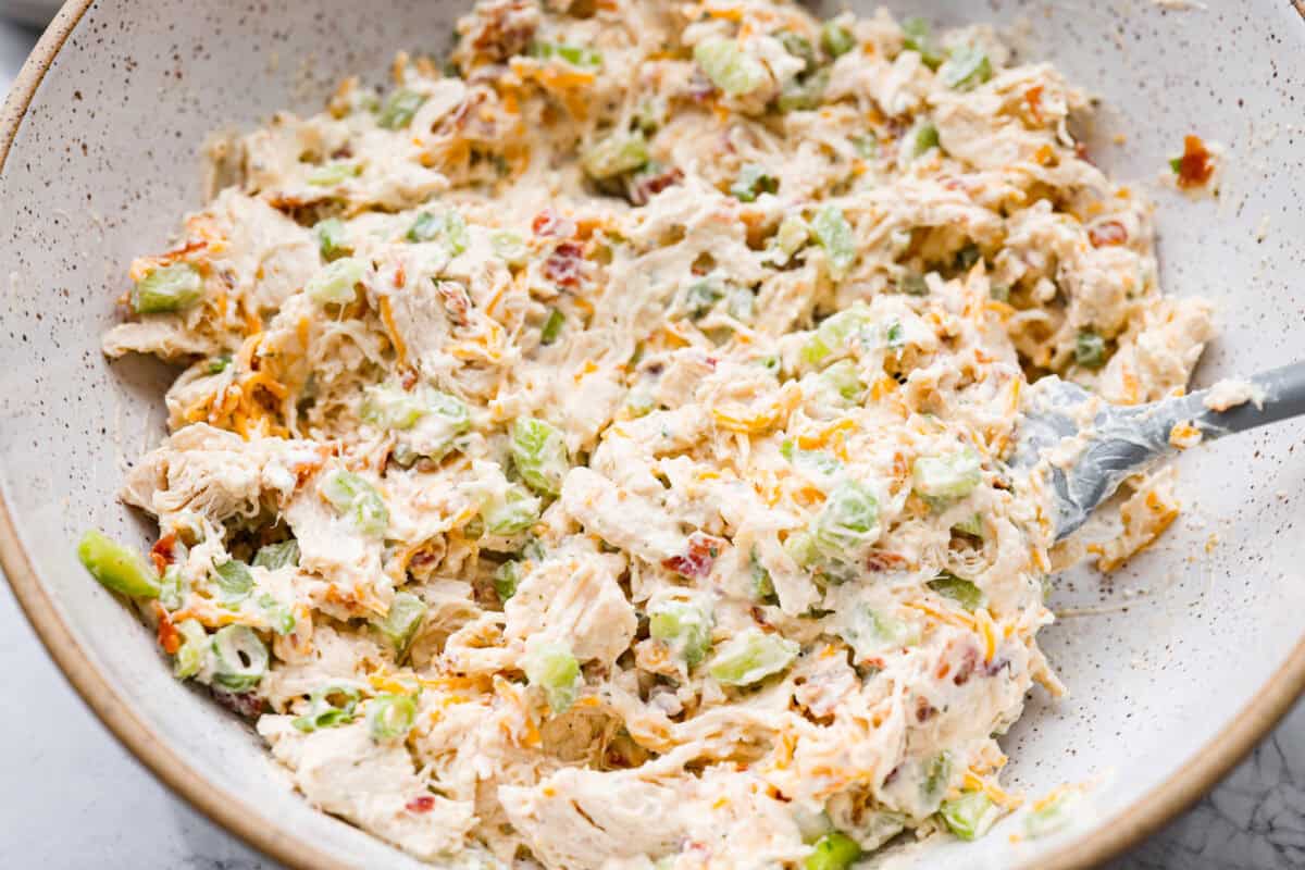 This crack chicken salad has no business being this good! It’s creamy, packed with ranch, bacon, and cheddar, and disappears way too fast. Pile it on a croissant or eat it straight from the bowl. I promise I won't judge! All of the ingredients for crack chicken salad all mixed together.